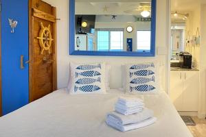 a bedroom with a bed with blue walls and a mirror at National Seashore Studio in Truro