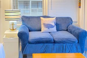 a blue couch with a pillow on it in a living room at National Seashore Studio in Truro