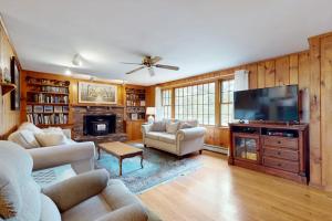a living room with a fireplace and a tv at Herring Brook in Eastham