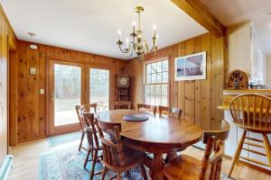 a dining room with a wooden table and chairs at Herring Brook in Eastham