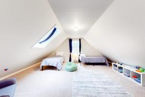 a attic room with two beds and a window at Lisa Lane in Mashpee