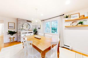 a dining room with a wooden table and white chairs at Lisa Lane in Mashpee +38 photos