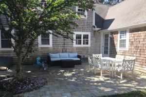 a patio with a blue couch and a table and chairs at Lisa Lane in Mashpee