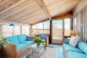 a living room with two blue couches and a table at Lobsterville Landing in Lobsterville