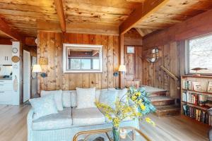 a living room with a couch and wooden walls at Lobsterville Landing in Lobsterville
