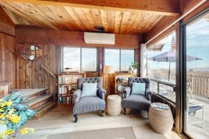 a living room with two chairs and a balcony at Lobsterville Landing in Lobsterville