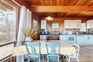 a kitchen with a table and blue chairs in a room at Lobsterville Landing in Lobsterville +30 photos