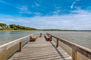 a wooden pier with benches on the water at Capeview Estate in Bourne