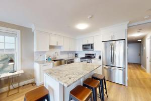 a kitchen with white cabinets and a granite counter top at Summer Cape Escape in Dennis Port +17 photos