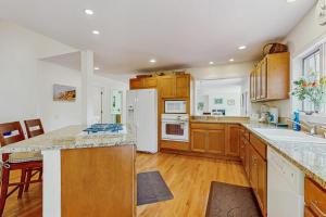 a large kitchen with wooden cabinets and a white refrigerator at Family Getaway in Oak Bluffs +15 photos