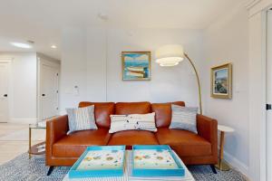 a living room with a brown couch and a table at Fun in the Sun in Provincetown