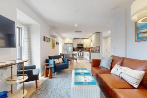a living room with a brown couch and a kitchen at Fun in the Sun in Provincetown