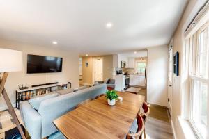 a living room with a blue couch and a wooden table at The Cape House in Cotuit