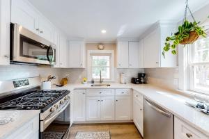 a kitchen with white cabinets and a stove at The Cape House in Cotuit