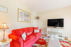 a living room with a red couch and a flat screen tv at Main Street Upper in Vineyard Haven