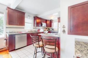 a kitchen with wooden cabinets and two bar stools at Main Street Upper in Vineyard Haven