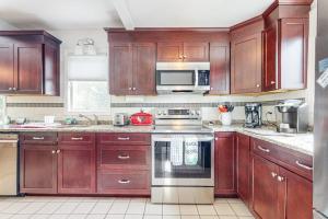 a kitchen with wooden cabinets and a stove top oven at Main Street Upper in Vineyard Haven +12 photos