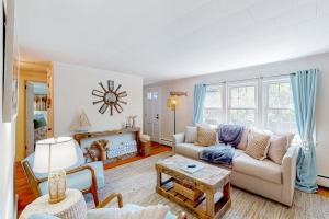 a living room with a couch and a table at Downtown Seaside Serenity Retreat in Hyannis