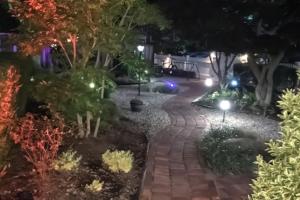 a walkway in a garden at night with lights at Captivating Cottage in Provincetown