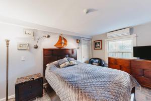 a bedroom with a bed and a flat screen tv at Captivating Cottage in Provincetown