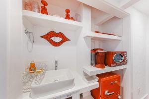 a white bathroom with a sink and a microwave at Captivating Cottage in Provincetown