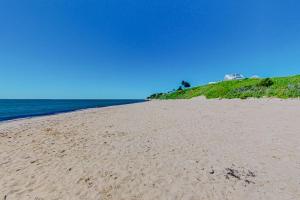 a sandy beach with the ocean in the background at Shoreline Escape in Mashpee