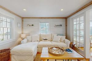 a living room with a white couch and windows at Shoreline Escape in Mashpee
