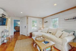 a living room with a white couch and a table at Shoreline Escape in Mashpee