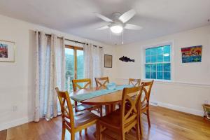 a dining room with a table and chairs and a ceiling fan at Tall Pines in Wellfleet +42 photos