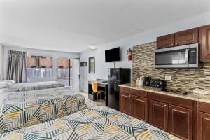a hotel room with two beds and a kitchen at Studio 6 Wilmington, NC in Wilmington