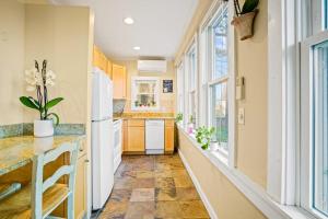 a kitchen with yellow walls and a large window at Lady Burns' Lookout in Provincetown