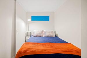 a bedroom with a bed with an orange and blue blanket at Lady Burns' Lookout in Provincetown +17 photos