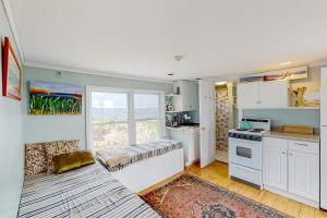 a kitchen with white cabinets and a large window at Bayview Escape in Provincetown