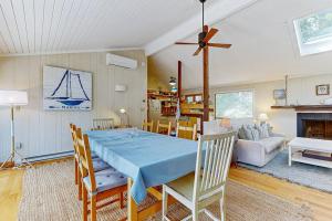 a dining room with a blue table in a living room at Drummer Cove Retreat in Wellfleet