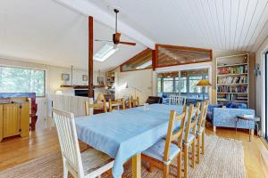 a dining room and living room with a table and chairs at Drummer Cove Retreat in Wellfleet