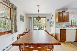 a kitchen with a large wooden table and chairs at Sandpiper's Saltbox in Dennis
