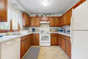 a kitchen with wooden cabinets and a white refrigerator at Sandpiper's Saltbox in Dennis