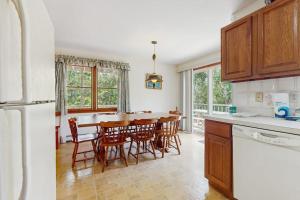 a kitchen with a table and chairs and a refrigerator at Sandpiper's Saltbox in Dennis