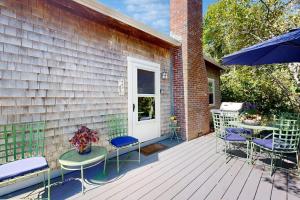 a wooden deck with chairs and a table and an umbrella at The Lodge in Provincetown