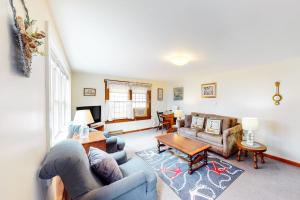 a living room with a couch and a table at Nauset Beach Getaway in Orleans