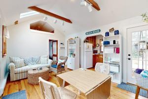 a living room with a wooden table and chairs at Cozy Escape on the Cape in Eastham