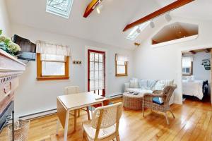 a living room with a table and chairs and a bed at Cozy Escape on the Cape in Eastham