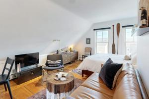 a bedroom with a bed and a couch and a tv at The Buoy Room in Provincetown