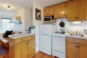 a kitchen with a white refrigerator and a sink at The Buoy Room in Provincetown +9 photos