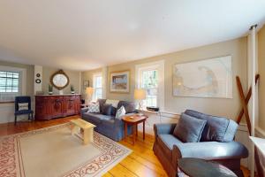a living room with two couches and a table at Gray Gables in Orleans