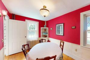 a dining room with a red wall at Gray Gables in Orleans