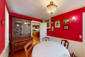 a room with a red wall with a table in it at Gray Gables in Orleans +31 photos