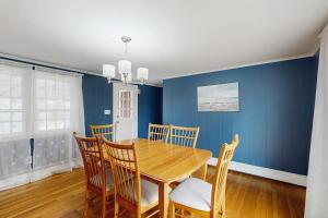 a dining room with a wooden table and chairs at Captain's Escape in South Yarmouth