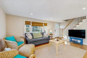 a living room with a couch and a tv at Seabreeze Escape in Falmouth