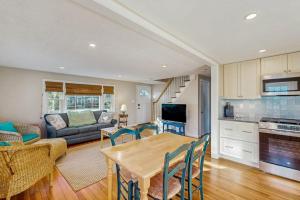 a kitchen and living room with a table and a couch at Seabreeze Escape in Falmouth